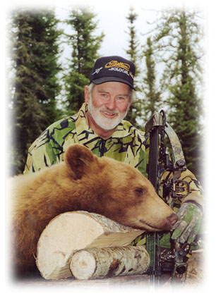 Photo of nice cinnamon bear with hunter in camo